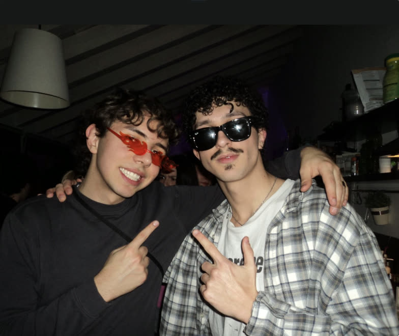 Two friends in sunglasses posing at a party