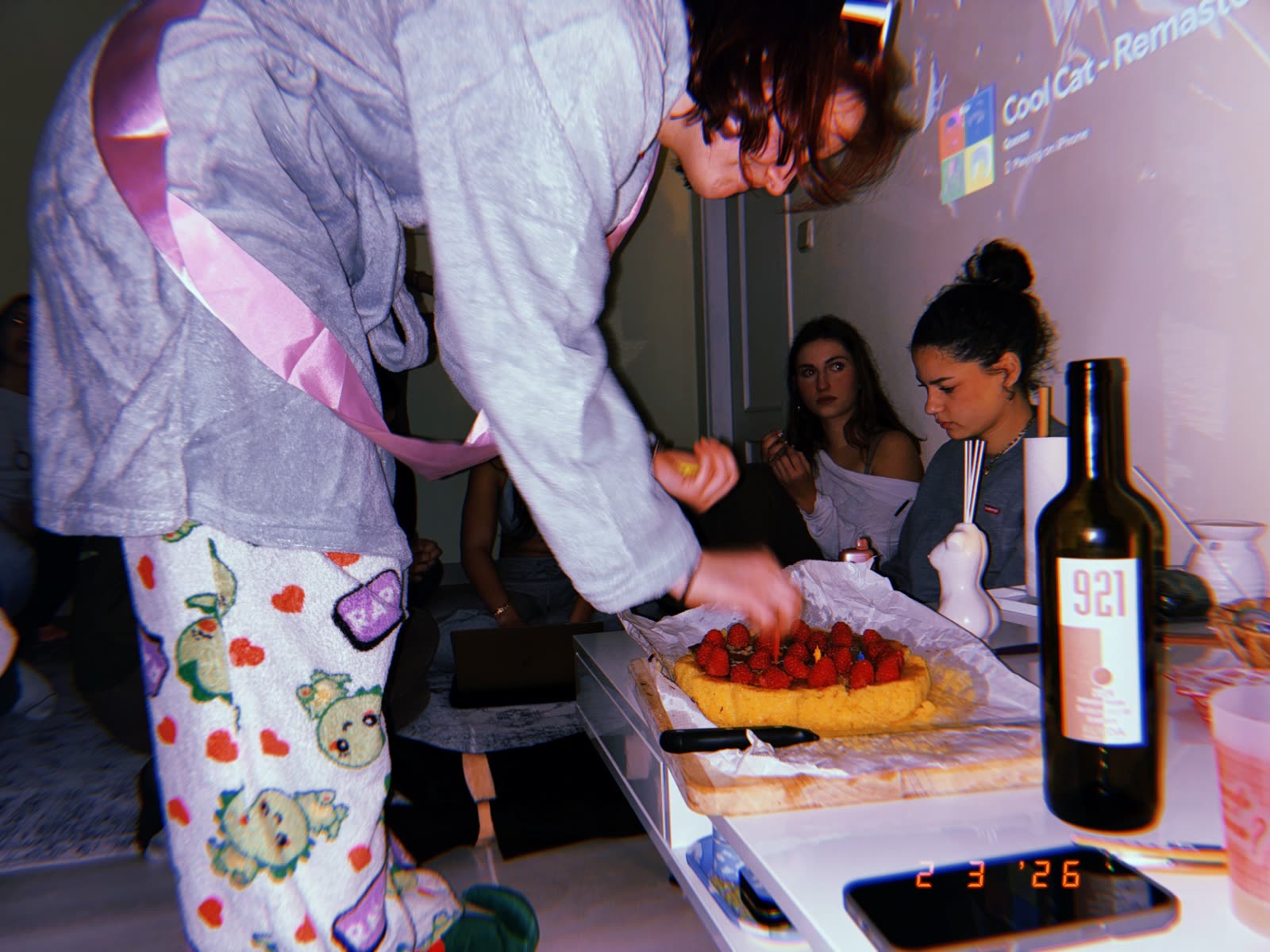 Friends decorating a strawberry tart at a late-night hangout